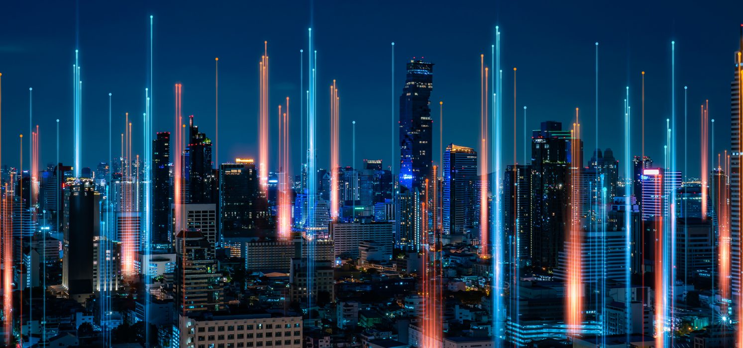 Pictorial representation of vulnerabilities such as CVE-2024-0012 and CVE-2024-9474. A panoramic nighttime view of city skyline with illuminated high-rise buildings and vibrant lights.