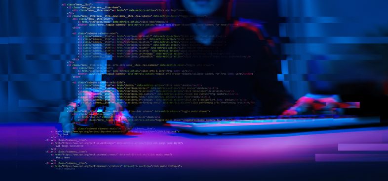 Pictorial representation of the npm packages supply chain attack. A blurred image focusing on a person typing on a laptop with lines of code visible on the screen, illuminated in blue and red lights, suggestive of intense coding or cyber activities.