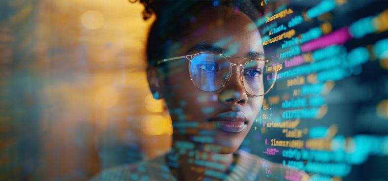 Close-up of a black woman with glasses examining colorful computer code on a screen. The scene is illuminated by various lights, creating a focused and analytical atmosphere.