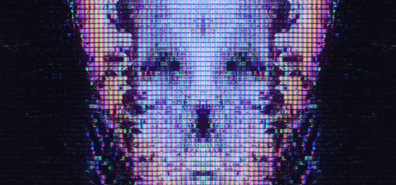 Pictorial representation of identity abuse through trusted communication channels. Close-up view of a digital screen displaying a glitched and pixelated image of a skull-like shape.